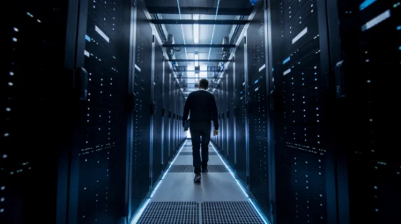 Technicien se déplaçant dans un datacenter pour superviser des infrastructures IT et serveurs