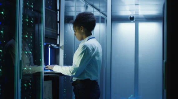 Technicienne IT intervenant sur des serveurs dans un datacenter pour la gestion d’infrastructure informatique