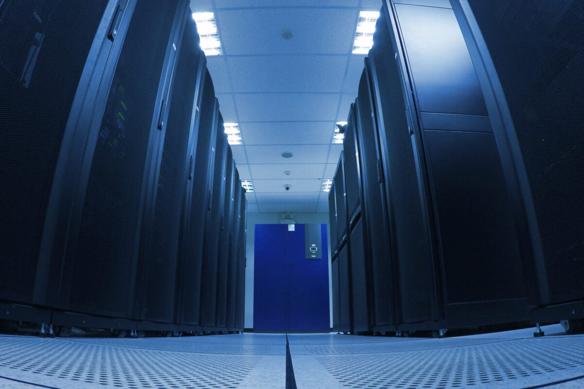 Allée d'un data center avec des baies de serveurs hébergeant les infrastructures informatiques des entreprises.