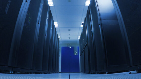 Allée d'un data center avec des baies de serveurs hébergeant les infrastructures informatiques des entreprises.